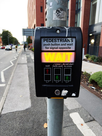 Close-up view of pedestrian push button at a city crosswalk, UK