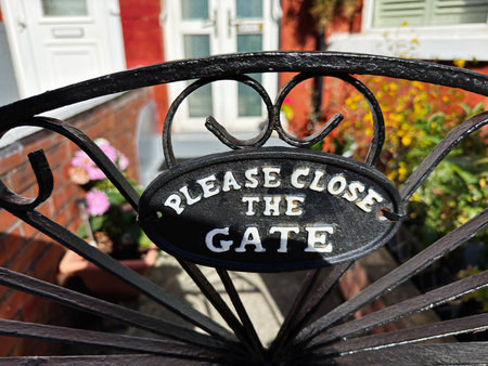 Wrought iron ornamental gate with a Please close the gate sign at a Manchester UK residence.の写真素材