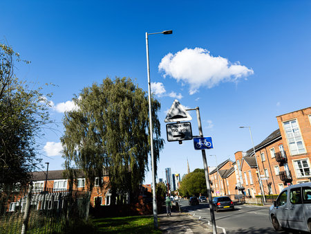 Bright afternoon in Manchester showing a residential street, bike lane sign, and calm traffic.の写真素材