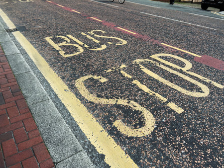 Busy Manchester street shows bus lane markings, cyclists and vehicles in a lively city.