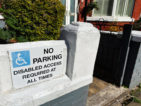 Wheelchair sign and gated front entrance at a Manchester home, highlighting accessibility and parking restrictions.の写真素材