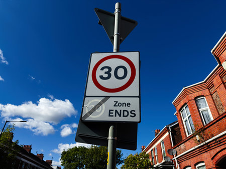 Manchester street scene with a 30 zone ends sign against a clear blue sky.の写真素材