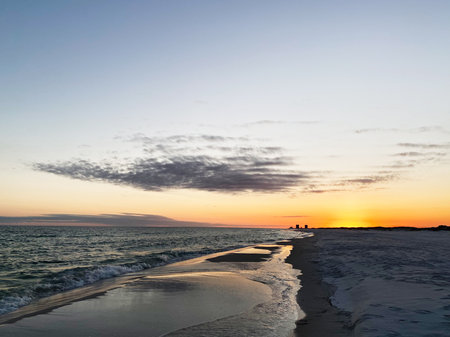 Calm Florida sunset over the ocean, with a sandy beach and reflective water at dusk.の写真素材