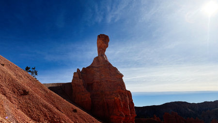 Towering red rock hoodoo rises against a clear blue sky in Utah desert. Bryce Canyon National Parkの写真素材