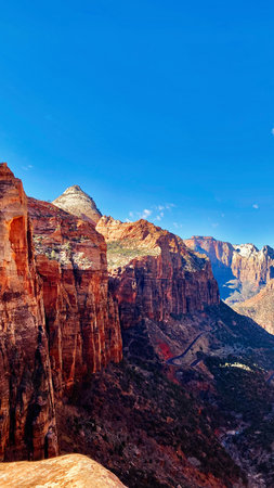 Vast canyon walls rise beneath a clear blue sky, a striking Utah landscape of red rocks and cliffs. Zion National Parkの写真素材