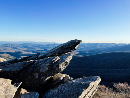 Rocky Rough Ridge cliff edge frames distant blue ridges in North Carolina landscape under a clear sky. Blue Ridge Parkwayの写真素材