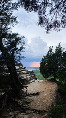 Serene forest trail along a cliff edge with sunset glow in Southern Illinois, inviting exploration...