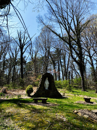 A serene woodland shrine houses a statue in a stone alcove among bare trees in Indiana.の写真素材