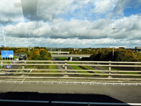 Dublin, Ireland - October 21, 2025: Roadway overpasses in Ireland beneath dramatic clouds with green trees and light traffic.のeditorial素材