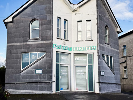 Castlerea, Ireland - October 21, 2025: Credit Union office in Ireland with grey stone facade and glass entrance doors, modern and civic.のeditorial素材