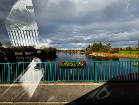 Edgeworthstown, Ireland - October 21, 2025: Peaceful Ireland river scene with teal railing, colorful...