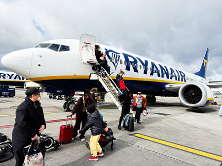 Dublin, Ireland - October 21, 2025: Passengers with luggage and strollers board a Ryanair aircraft at Dublin airport under cloudy skies.のeditorial素材