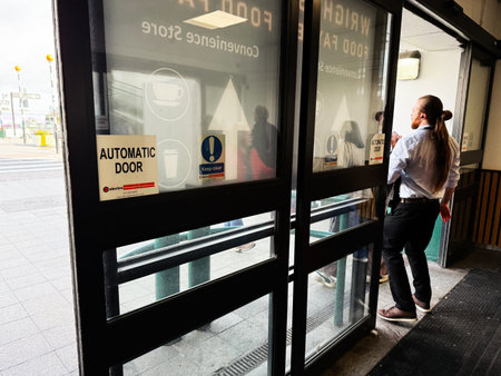 Dublin, Ireland - October 21, 2025: Two people near an automatic door in a Dublin transit station lobby, casual business mood and everyday urban life.のeditorial素材