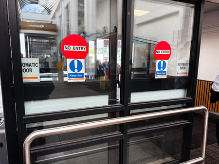 Dublin, Ireland - October 21, 2025: Red no entry signs and blue keep clear notices on glass doors at...