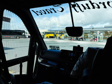 Dublin, Ireland - October 21, 2025: Passengers and driver in a taxi view a Dublin bus terminal with buses and waiting crowds.のeditorial素材