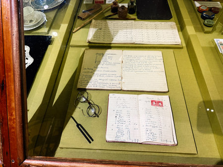 Knock, Ireland - October 22, 2025: A vintage desk display featuring notebooks, glasses, and writing tools in Knock, Ireland.のeditorial素材