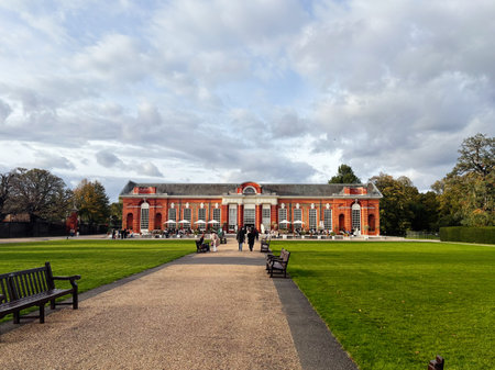 London, UK - October 05, 2025: A sunny day at a London Kensington Palace park shows a historic brick building, benches, and strolls.のeditorial素材