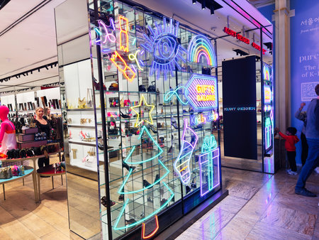 Stretford, UK - November 15, 2025: Bright neon Kurt Geiger storefront in Manchester showcasing festive gifts and accessories.のeditorial素材