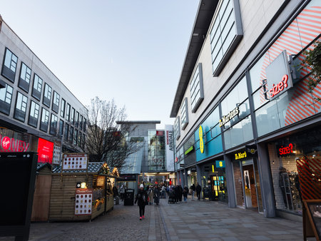 Manchester, UK - November 19, 2025: Lively Manchester street scene with shops, market stalls, and pedestrians in a modern shopping area.のeditorial素材