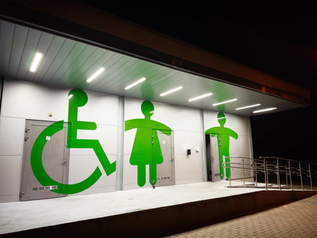 Night scene in Poland showing large green accessibility symbols on restroom doors.の写真素材