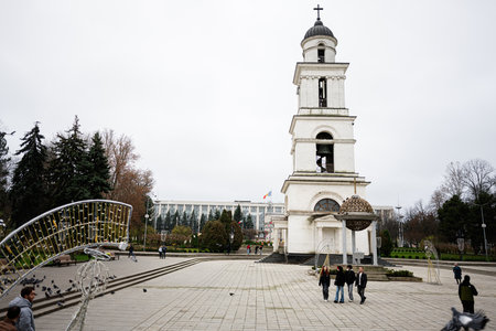 Chisinau, Moldova - November 22, 2025: A plaza centered on a tall white church tower in Chisinau,...