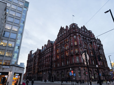 Manchester, UK - December 10, 2025: Historic red brick building in Manchester contrasts with a glass office tower on a busy city Oxford street.のeditorial素材
