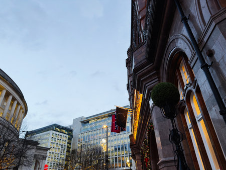 Manchester, UK - December 10, 2025: Evening scene in Manchester with historic architecture, The Midland hotel  festive lights and warm glow along a city street.のeditorial素材