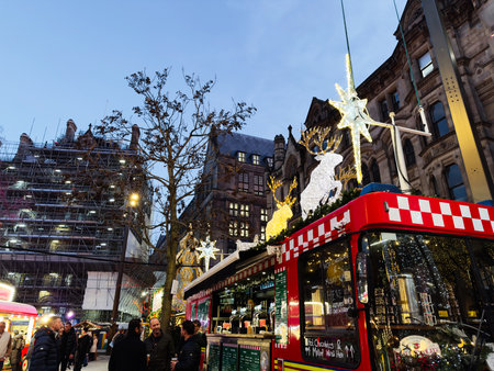 Manchester, UK - December 10, 2025: Lively festive street scene in Manchester with Christmas decorations, bright lights, and a red bus.のeditorial素材