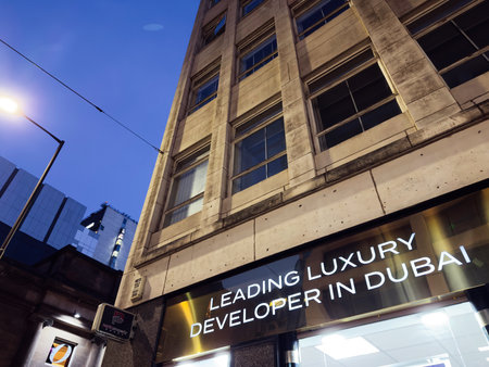 Manchester, UK - December 10, 2025: Night street scene in Manchester with a bold storefront...