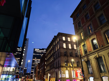 Manchester, UK - December 10, 2025: A vibrant nighttime Charlotte cityscape in Manchester featuring warm street lights, classic architecture, and glass facades.のeditorial素材