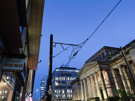 Manchester, UK - December 10, 2025: Manchester street view with Caffe Nero cafe sign, modern glass buildings, and classical columns at blue hour.のeditorial素材