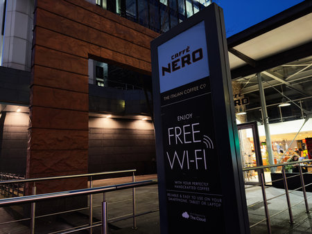 Manchester, UK - December 10, 2025: Urban coffee shop sign advertising free Wi-Fi in Manchester inviting customers to enjoy crafted coffee.のeditorial素材