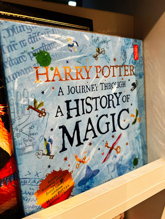 London, UK - December 12, 2025: Book cover showing Harry Potter history of magic exhibit title on blue illustrated background.のeditorial素材