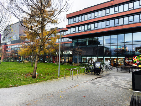 Manchester, UK - December 06, 2025: University urban scene in Manchester featuring modern architecture, bicycles, a cafe and green space.のeditorial素材