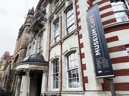Manchester, UK - December 06, 2025: Historic building in Manchester with a tall banner advertising a cafe inside the museum area.のeditorial素材