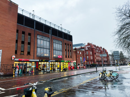 Manchester, UK - December 06, 2025: Rainy day on a Manchester street with brick facades, bikes and...