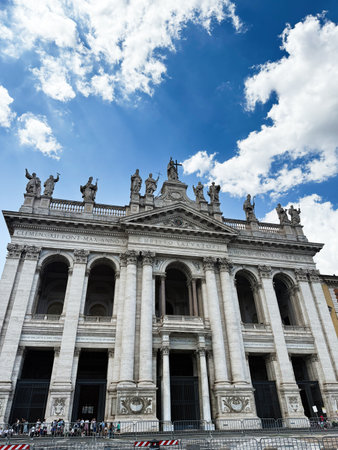 Rome, Italy - July 30, 2025: Grand historic church facade with statues, arches and tall columns under a bright blue sky. Archbasilica of Saint John Lateranのeditorial素材