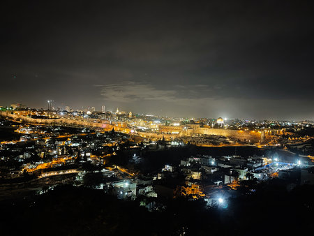 Jerusalem, Israel - December 03, 2022: A sweeping night view of Jerusalem displaying historic walls, illuminated domes, and urban glow.のeditorial素材