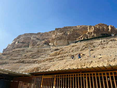 Jerusalem, Israel - December 03, 2022: Bright day at Masada with ancient stone terraces and hikers...