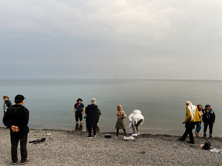 Jerusalem, Israel - December 03, 2022: Tourists and locals mingle on a pebbled beach near the Dead...