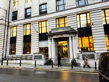 Manchester, UK - January 21, 2026: Historic Manchester Blackfriars House building entrance with warm interior lighting and people walking by.のeditorial素材