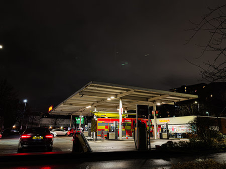 Manchester, UK - January 21, 2026: Night scene at a Manchester petrol station featuring a red emergency vehicle near a Sainsburyâs store.のeditorial素材
