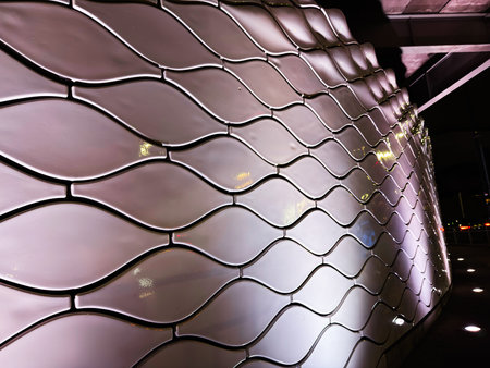 Manchester, UK - January 21, 2026: Curved metallic tiles form a flowing Tower of Light facade with reflective surfaces under city lights in Manchester.のeditorial素材