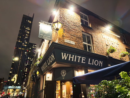 Manchester, UK - January 21, 2026: A night scene outside the White Lion pub in Manchester, showcasing brick exterior, warm lights, and bustling streets.のeditorial素材