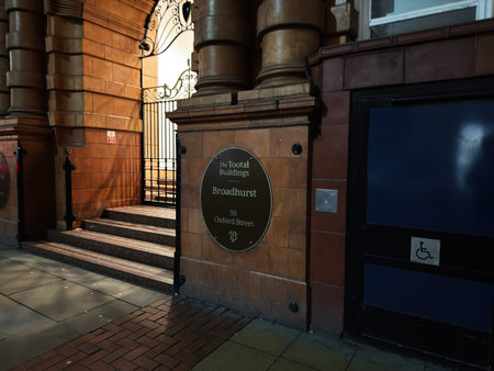 Manchester, UK - January 21, 2026: Brick entrance with steps and ornate ironwork, featuring a plaque for Broadhurst, The Tootal Buildings in Manchester.のeditorial素材