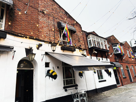 Manchester, UK - January 22, 2026: A lively Manchester street scene with brick New Union facades, hanging lights, rainbow LGBT flags, and outdoor seating.のeditorial素材