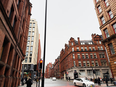 Manchester, UK - January 22, 2026: Urban scene in Manchester featuring red brick architecture, street traffic, and people on the sidewalk.のeditorial素材