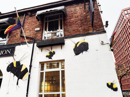 Manchester, UK - January 22, 2026: A Manchester New Union LGBT Hotel building features bold bee murals on a white wall with rainbow Pride flags.のeditorial素材