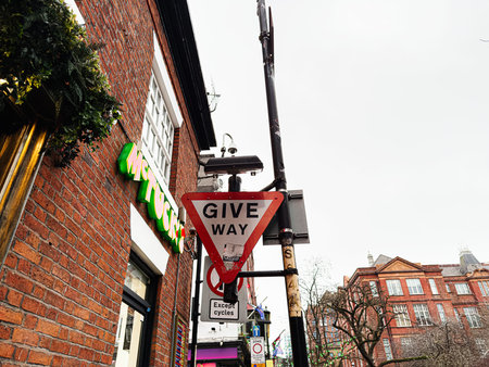 Manchester, UK - January 22, 2026: Urban street scene in Manchester featuring a give way sign, brick facade and storefronts nearby.のeditorial素材