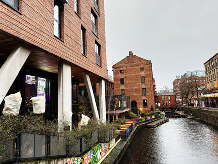 Manchester, UK - January 22, 2026: Urban canal scene in Manchester featuring brick architecture, modern supports, and colorful lights along the water, Minto and Turner Ltd.のeditorial素材